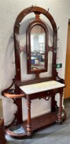 A VICTORIAN MAHOGANY HALL STAND centred with an arched shaped mirror, flanked by ten hat and coat