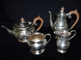 STERLING SILVER TEA SERVICE Comprising tea and coffee pots with brown wooden handles and finials,