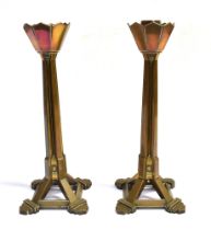 A PAIR OF BRONZE CANDLESTICKS early 20th century, each with a faceted drip pan and an angular