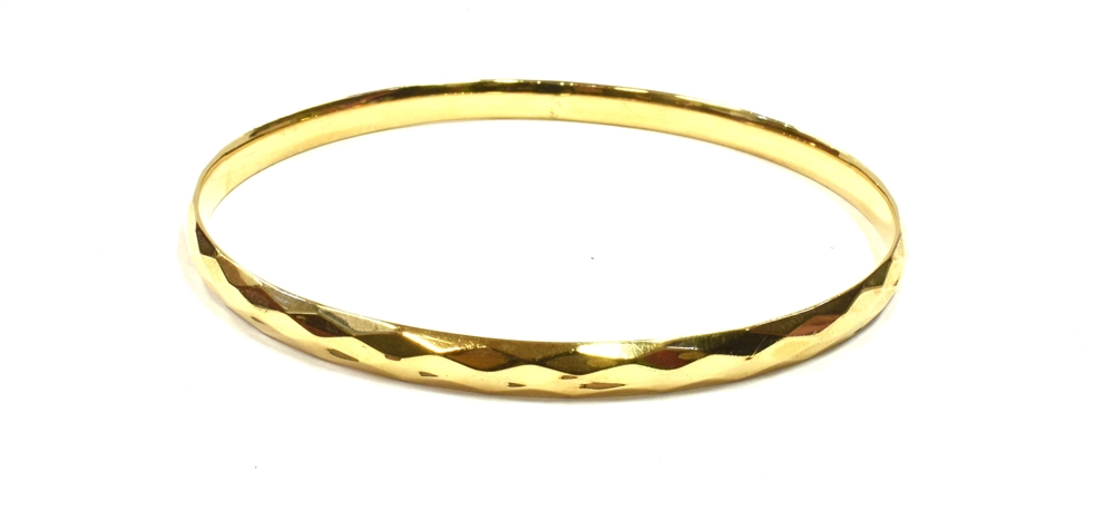 9CT GOLD METAL CORE BANGLE 8cm diameter, 5.7mm wide, with faceted decoration to exterior, smooth