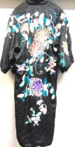 A CHINESE EMBROIDERED BLACK SILK ROBE mid 20th century, decorated with chrysanthemum and other