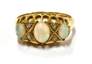 EDWARDIAN OPAL AND DIAMOND RING Three solid white opal oval cabochons, showing bright play of