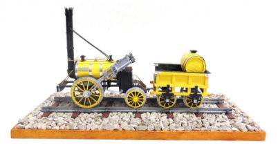 A SCRATCH-BUILT MODEL OF THE 'ROCKET' LOCOMOTIVE painted yellow and black, 28cm long, on a length of
