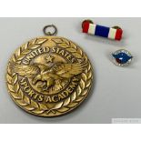 A bronze tone medallion, cloth colour bar, and enamel pin presented to Pelé