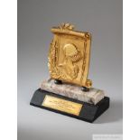 A gold tone trophy depicting a knight on two tiers of marble presented to Pelé