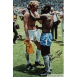 A large colour portrait photograph of the famous embrace between Pele and Bobby Moore