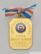 A yellow metal medal presented by the Chile Football Association to Ottorino Barassi on the occasion