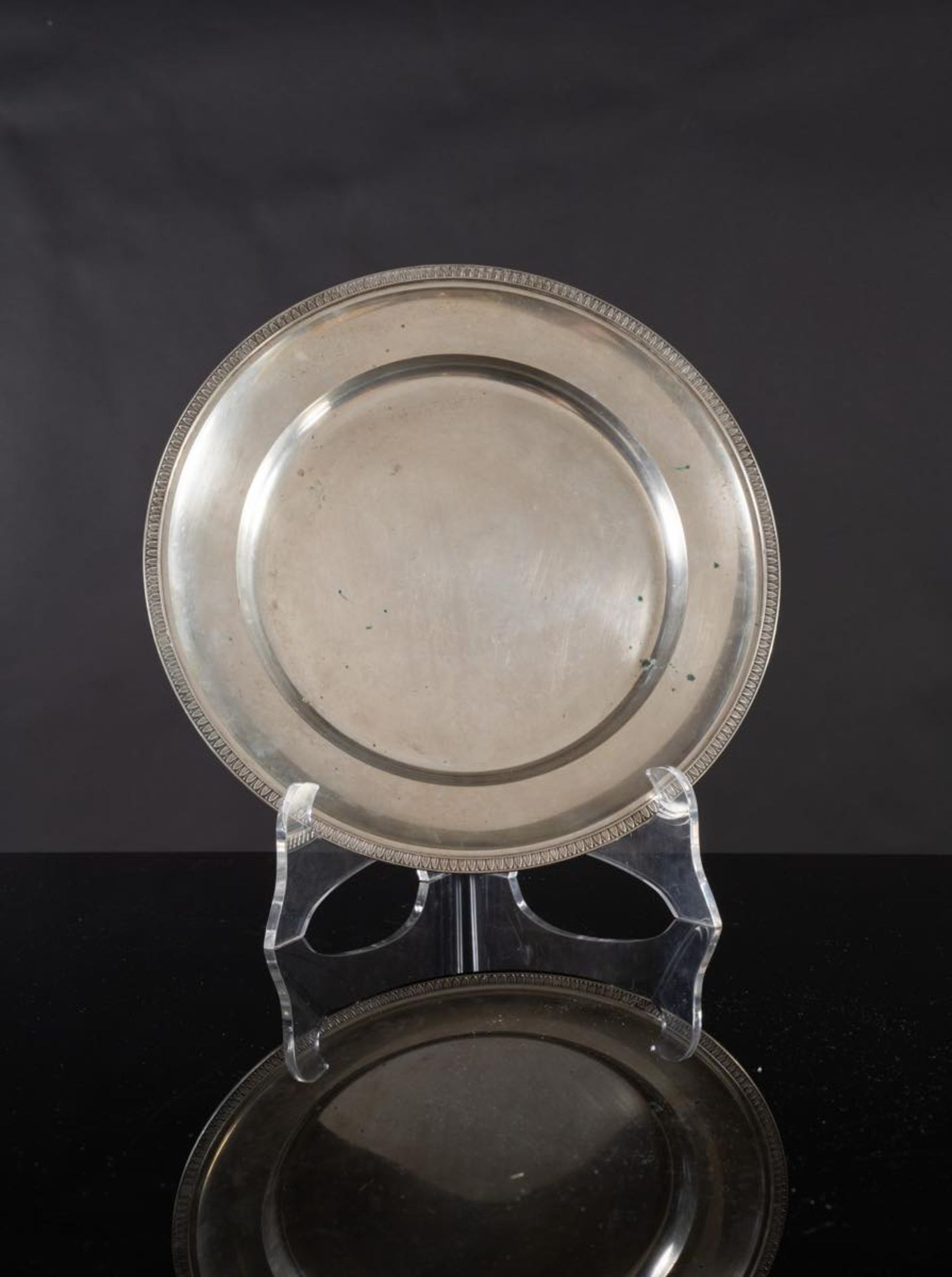 Piatto da portata circolare in argento, XX secolo.Superficie liscia, bordo decorato da motivo a