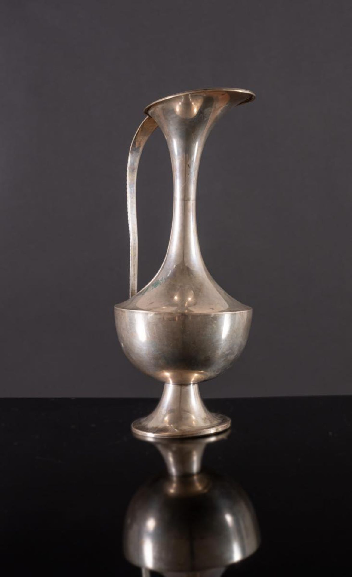 Versatoio in argento di gusto Liberty, Italia, inizi del XX secolo.Corpo a sezione circolare, lungo