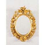 Specchiera ovale in legno intagliato e dorato, Toscana, metà del XIX secolo.Decorazione e motivi