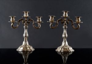 Coppia di candelieri a tre fiamme in argento, Italia, XX secolo. Corpo costolato poggiante su piede