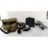 A photographer's bag containing Olympus OM10 and Minolta XG1 cameras, with lenses and accessories;