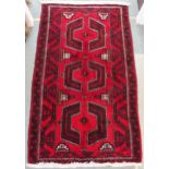 A red ground Turkoman rug with geometric central design and borders, 225cm long x 130cm wide