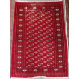 A red ground Bokhara rug with all-over lozenge design, 181cm long x 126cm wide Condition Report: