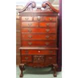 A 20th century mahogany chest on stand with scrolled shaped cornice over three short over two