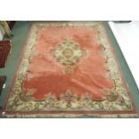 A large pink ground Oriental rug with floral central medallion and matching borders, 363cm long x