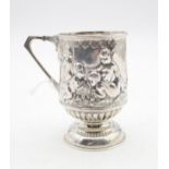 An Edwardian silver christening mug, of cylindrical form, with cast and embossed decoration of
