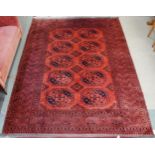 A terracotta ground Bokhara rug with all-over lozenge design and geometric borders, 282cm long x