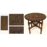 A 20th century circular occasional table with top carved Mayan pictographs on turned folding base,