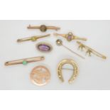 A collection of 9ct and yellow metal brooches to include an amethyst and pearl example, weight all
