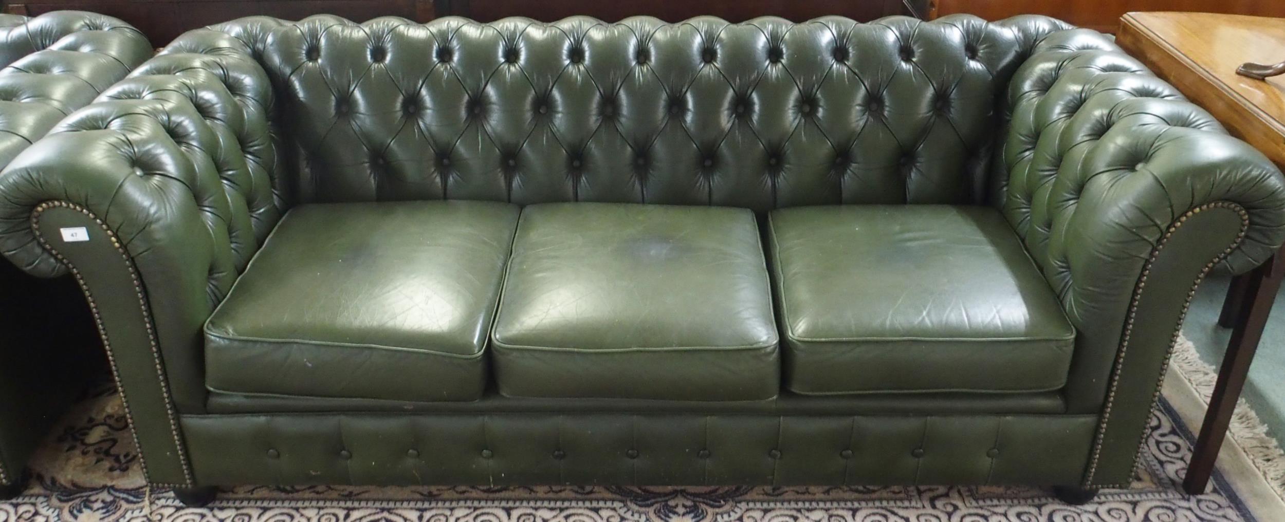 A 20th century green leather upholstered Chesterfield style three seater button back club settee