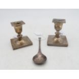 A pair of silver dwarf candlesticks, the bases with a Greek key border (weighted), by Walker & Hall,