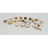 A collection of 9ct and yellow metal rings and a brooch, all are (AF) split, shanks stones missing