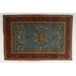 A light blue ground Qom rug with dark blue floral medallion, matching spandrels and red flower