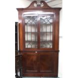 A large late Victorian astragal glazed corner cabinet with scrolled dentil cornice over pair of
