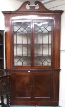 A large late Victorian astragal glazed corner cabinet with scrolled dentil cornice over pair of
