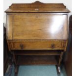 An early 20th century oak writing bureau with fall front writing compartment over single drawer,