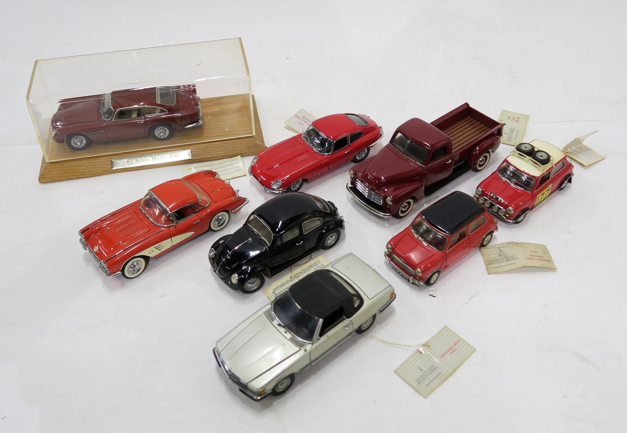 A small collection of Franklin Mint scale model vehicles, including an Aston Martin DB5 in Perspex