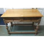 A 20th century honeyed oak two drawer hall table on stretchered turned supports, 78cm high x 104cm