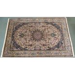 A CREAM GROUND MESHED RUG with blue starburst central medallion, matching spandrels and floral