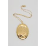 A large 9ct gold engraved locket, dimensions with bail 6.3cm, with a 9ct fancy link chain, length