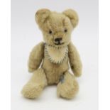 A miniature teddy bear by Chad Valley, with articulated limbs, standing approx. 12.5cm in height.