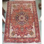 A red ground Tabriz rug with multicoloured central medallion, cream spandrels, floral patterned