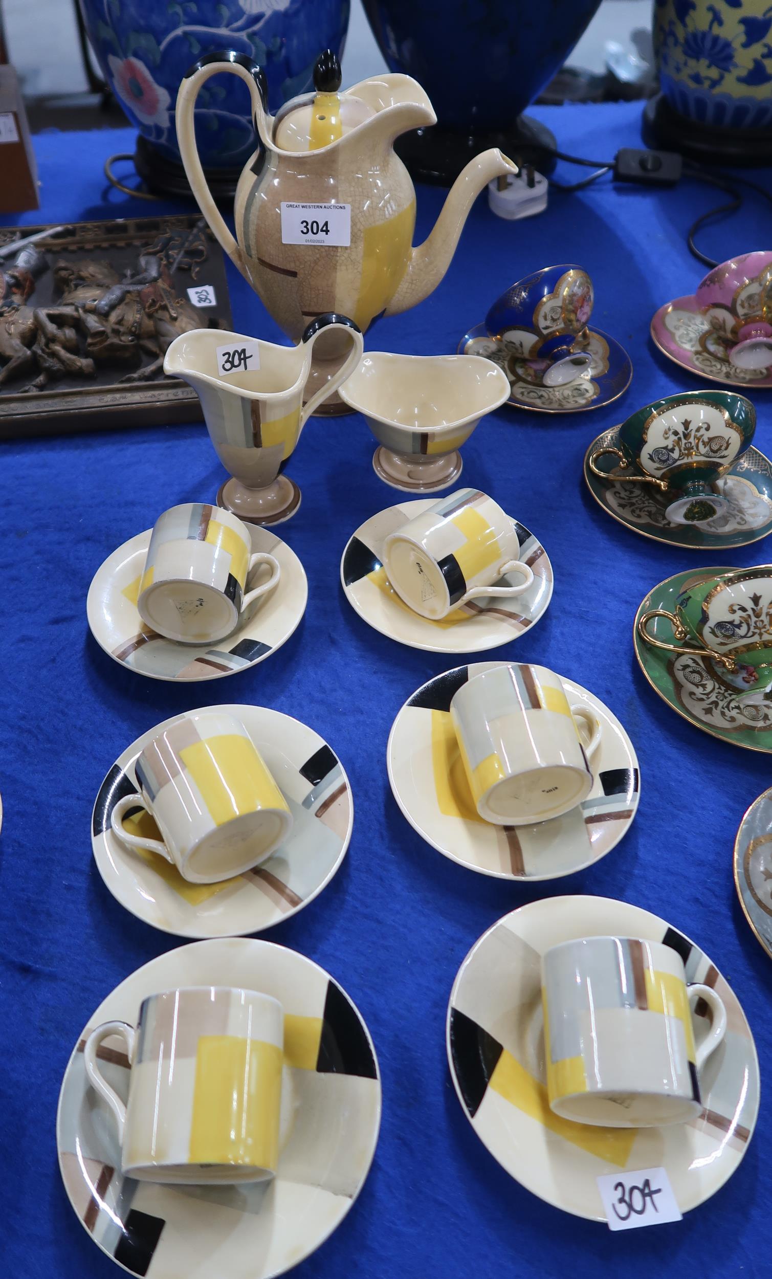 An Art Deco Susie Cooper coffee set with Geometric design of browns, grey, black and yellow on a