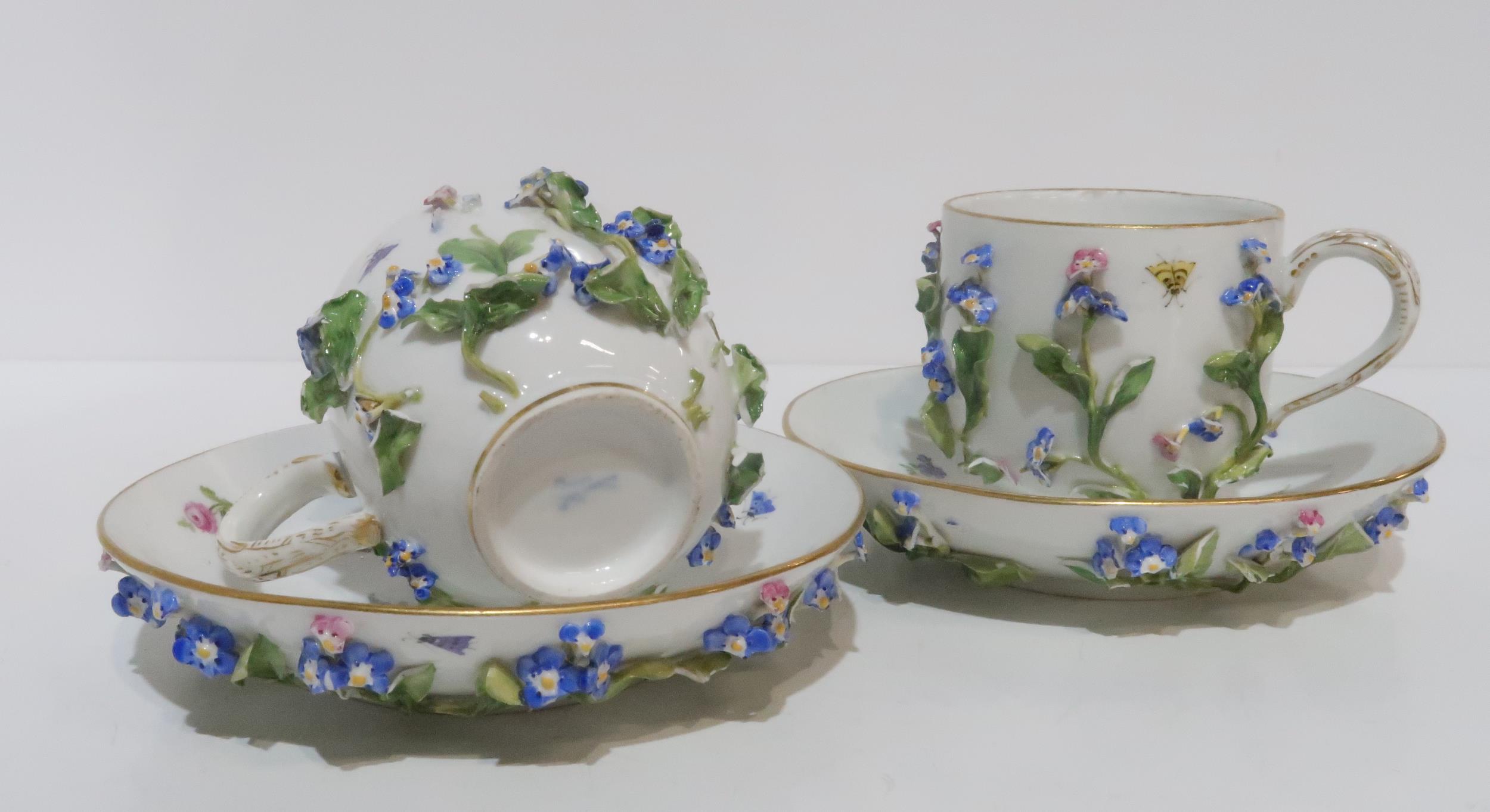 A pair of 19th century Meissen flower encrusted cups and saucers, each with additional painted - Image 2 of 2