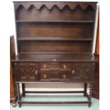 A 20th century oak Jacobean style kitchen dresser with two shelf open plate rack over two central