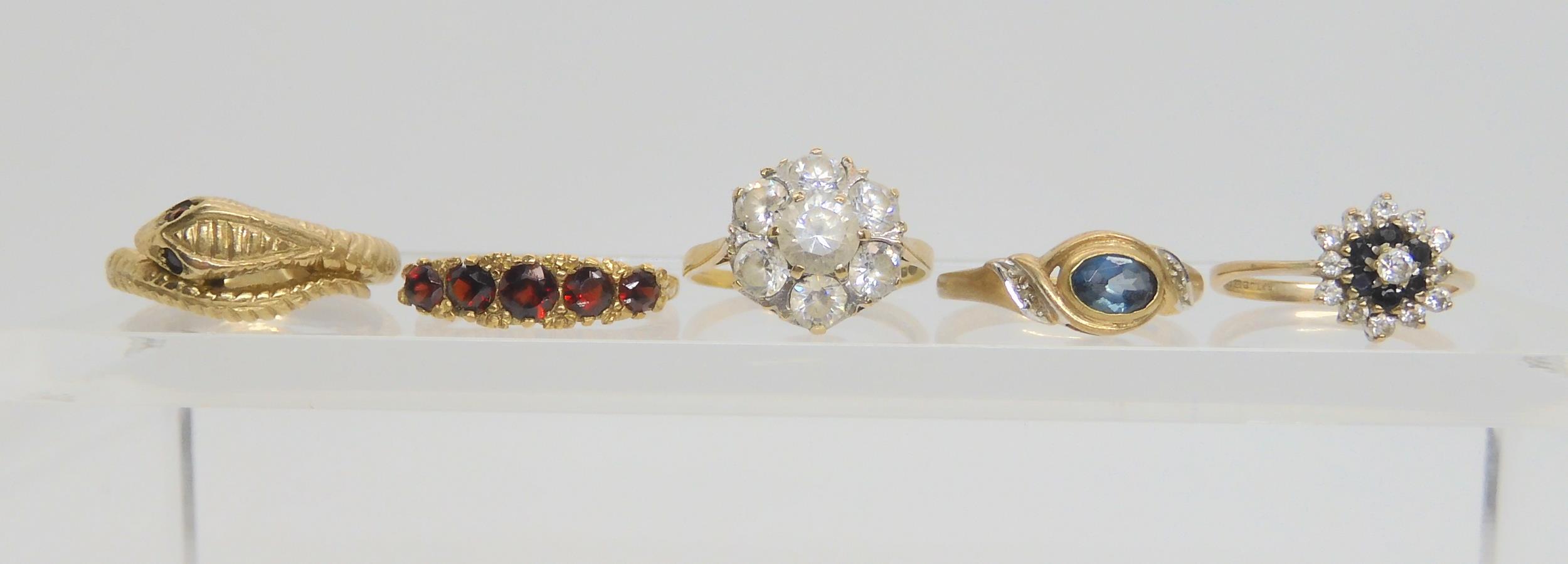 five 9ct gold gem set rings, to include a snake ring with garnet eyes, size P1/2, a five stone