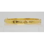 A 9ct gold engraved bangle of hollow construction, inner diameter 6cm, weight 8.4gms Condition