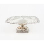 AN EDWARDIAN SILVER TAZZA of square form, with a cast openwork scrolling foliate rim, the two