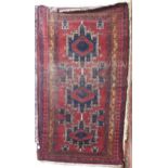 A RED GROUND CAUCASIAN KAZAK RUG with three geometric medallions and geometric multicoloured border,