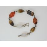 A carved Scottish agate bracelet, with some barley twist carved links, mounted in white metal.