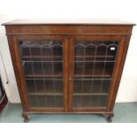 A 20th century oak glazed bookcase with pair of leaded glass doors on cabriole supports, 128cm