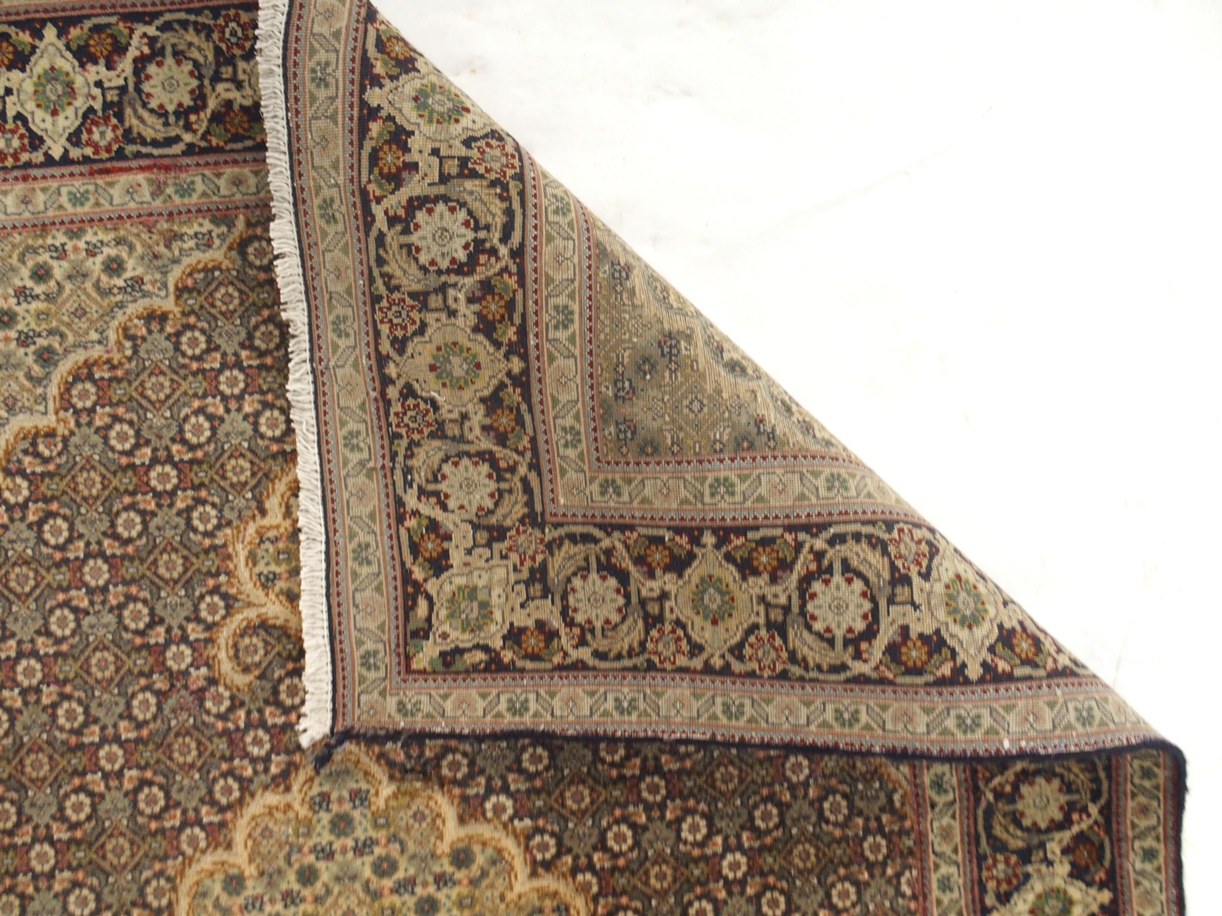 A multicoloured ground Tabriz rug with green central medallion, matching spandrels and a dark blue - Image 4 of 5