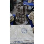 An embroidered table cloth, together with a pair of silver plated candelabra, a tray, an oak glass