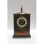 A French brass mantle clock, the dial with enamelled chapter ring with roman numerals, the