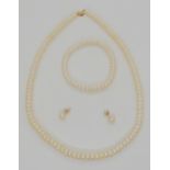 A string of cultured button pearls with a 14k gold clasp, with matching bracelet and earrings